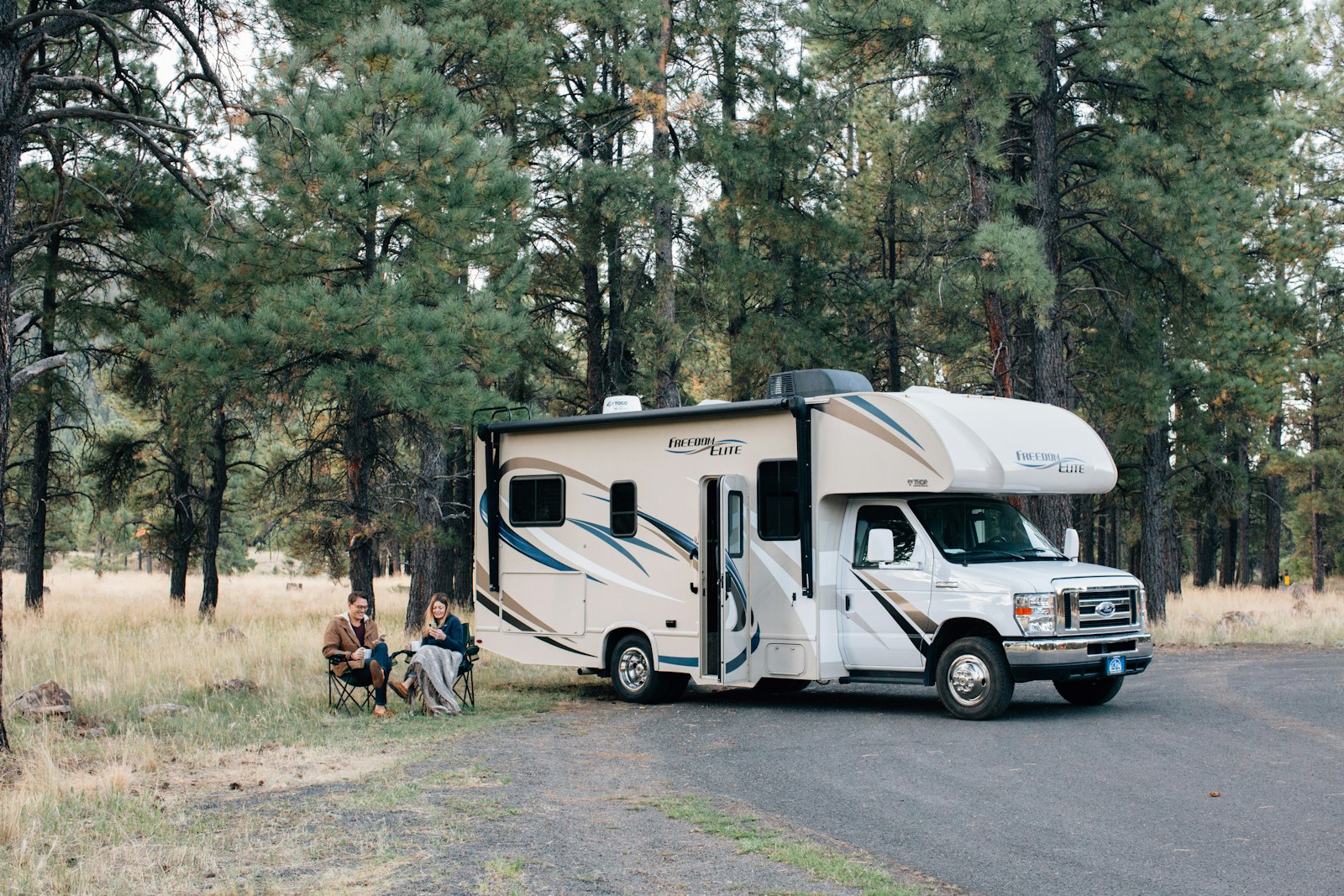 people standing near white rv trailer during daytime, recreational vehicle